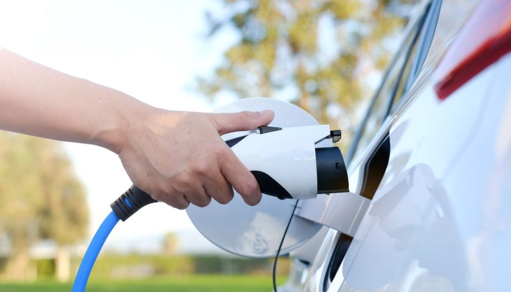 Electric car or ev is charging at station . man use the white po