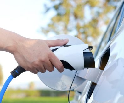 Electric car or ev is charging at station . man use the white po