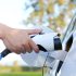 Electric car or ev is charging at station . man use the white po